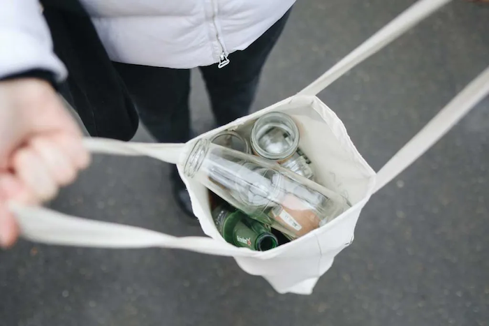 Reusable Swaps - woman holding reusable grocery bag Ditch Single-Use Plastic copy