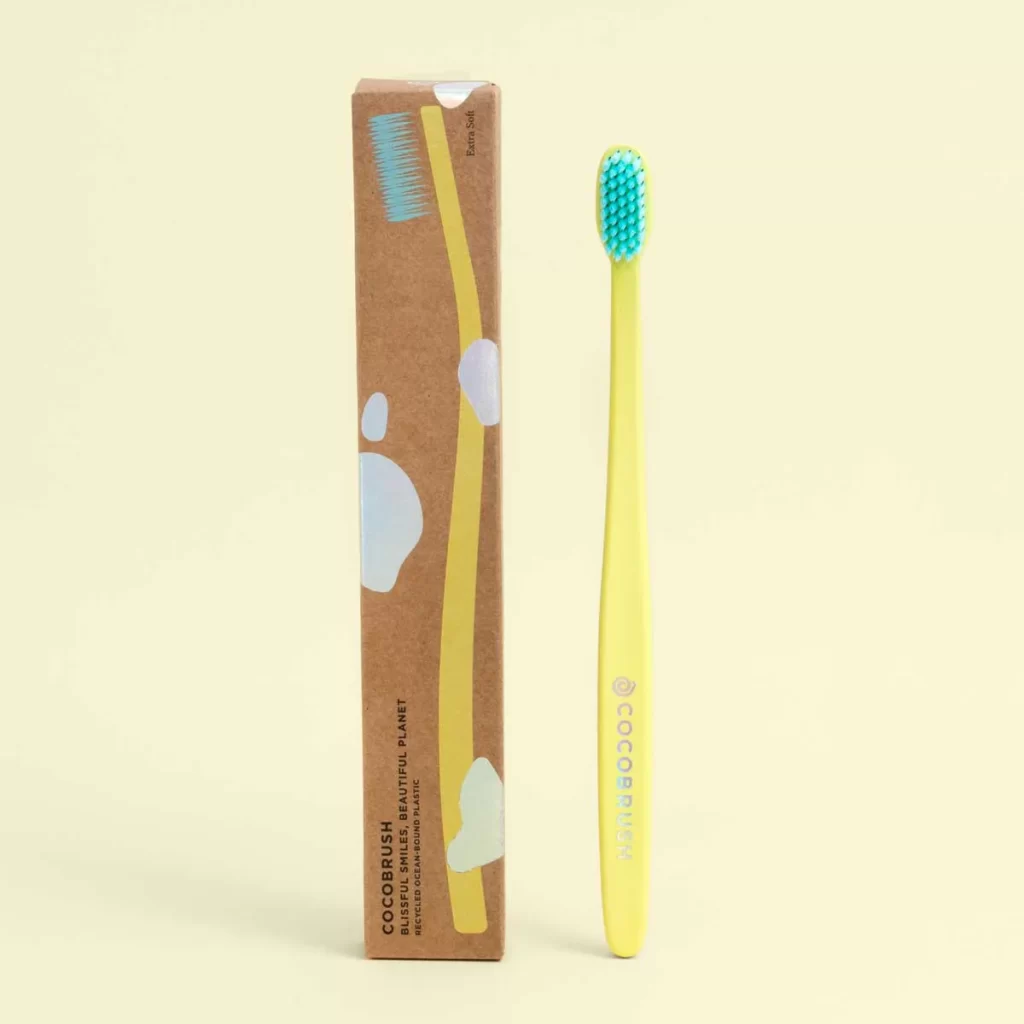 cocobrush tooth brush standing by packaging, detailing the best cocofloss review