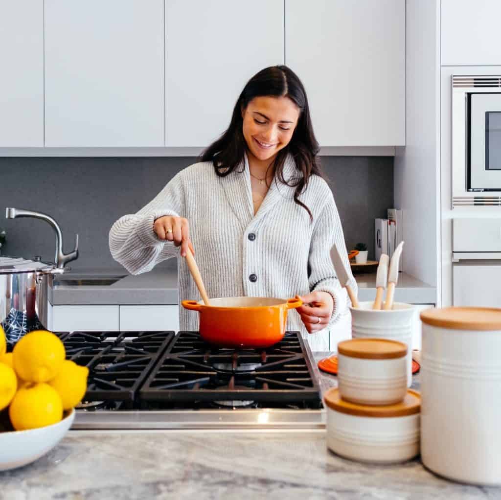 Woman in kitchen, cooking ingredients from her Gobble meal kit review. Wondering, how does Gobble work?